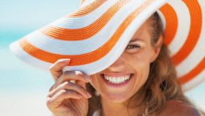 Portrait of happy young woman in swimsuit and beach hat