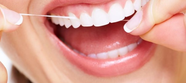 Closeup on young woman's teeth while she is flossing