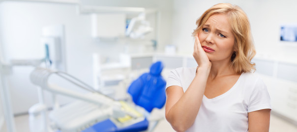 unhappy woman suffering toothache over dental office background