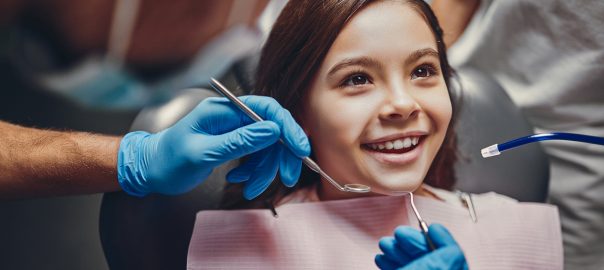 Young girl dentist checkup dental instruments, girl smiling front angle