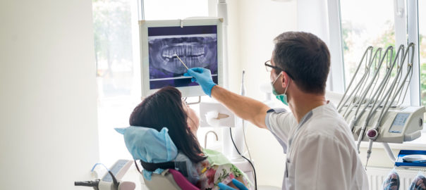 Doctor dentist showing patient's teeth on X-ray